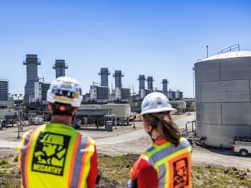 Two construction works looking out over combined cycle power plant site