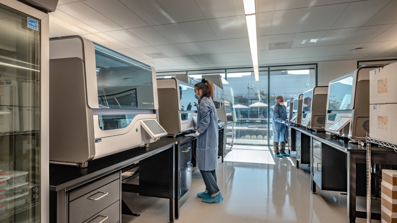A lab area with a person wearing a mask and working in the lab. 