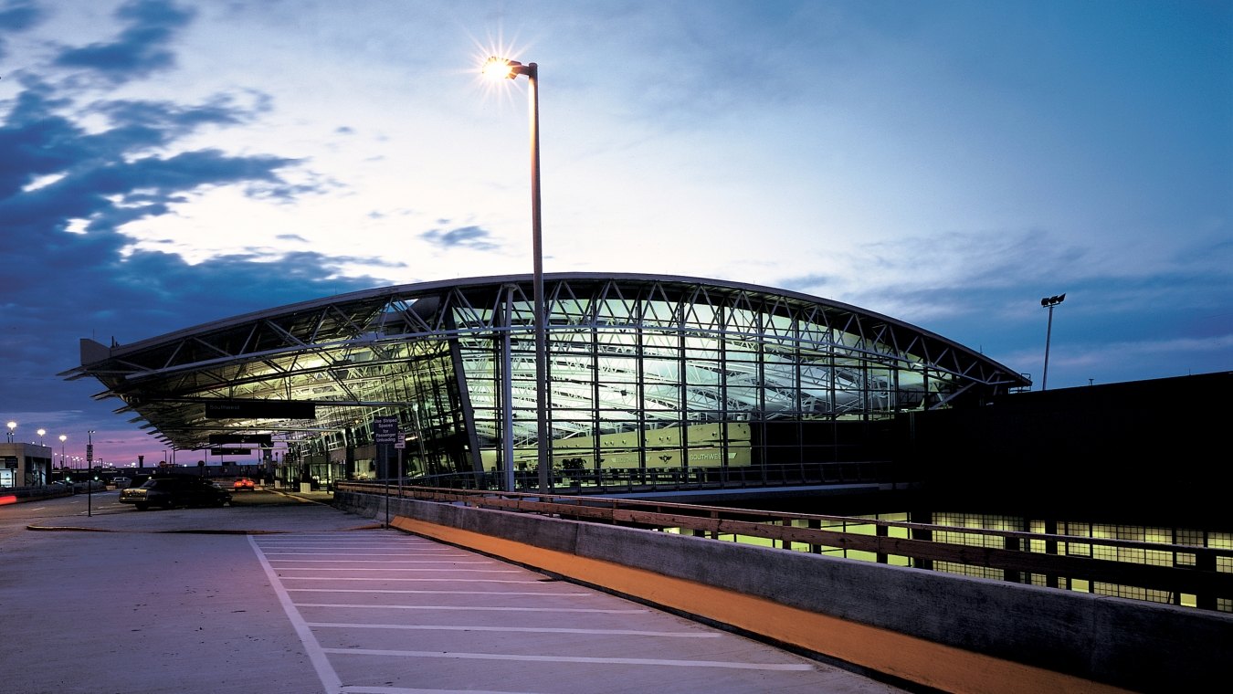 Outdoor image of a terminal thats completely glass and steal with clouds in the sky