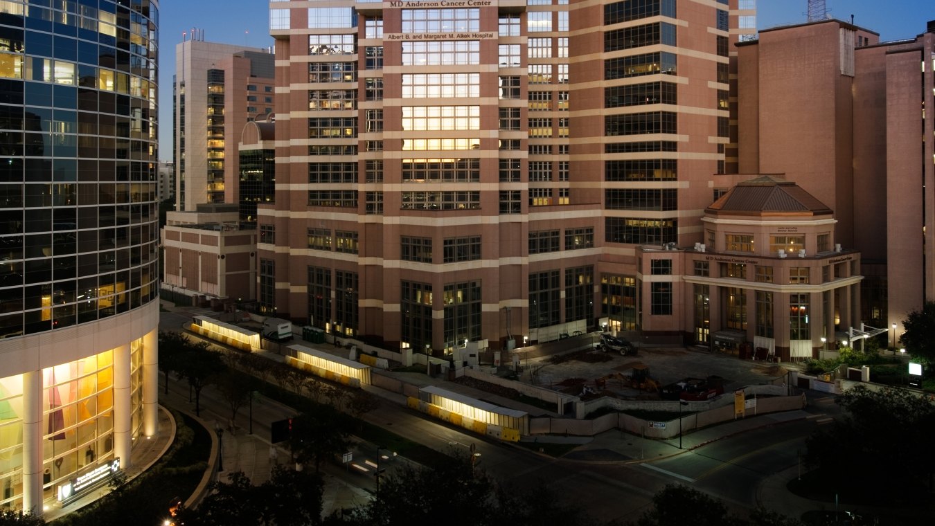 Exterior view of the tall hospital tower surrounded by other buildings.