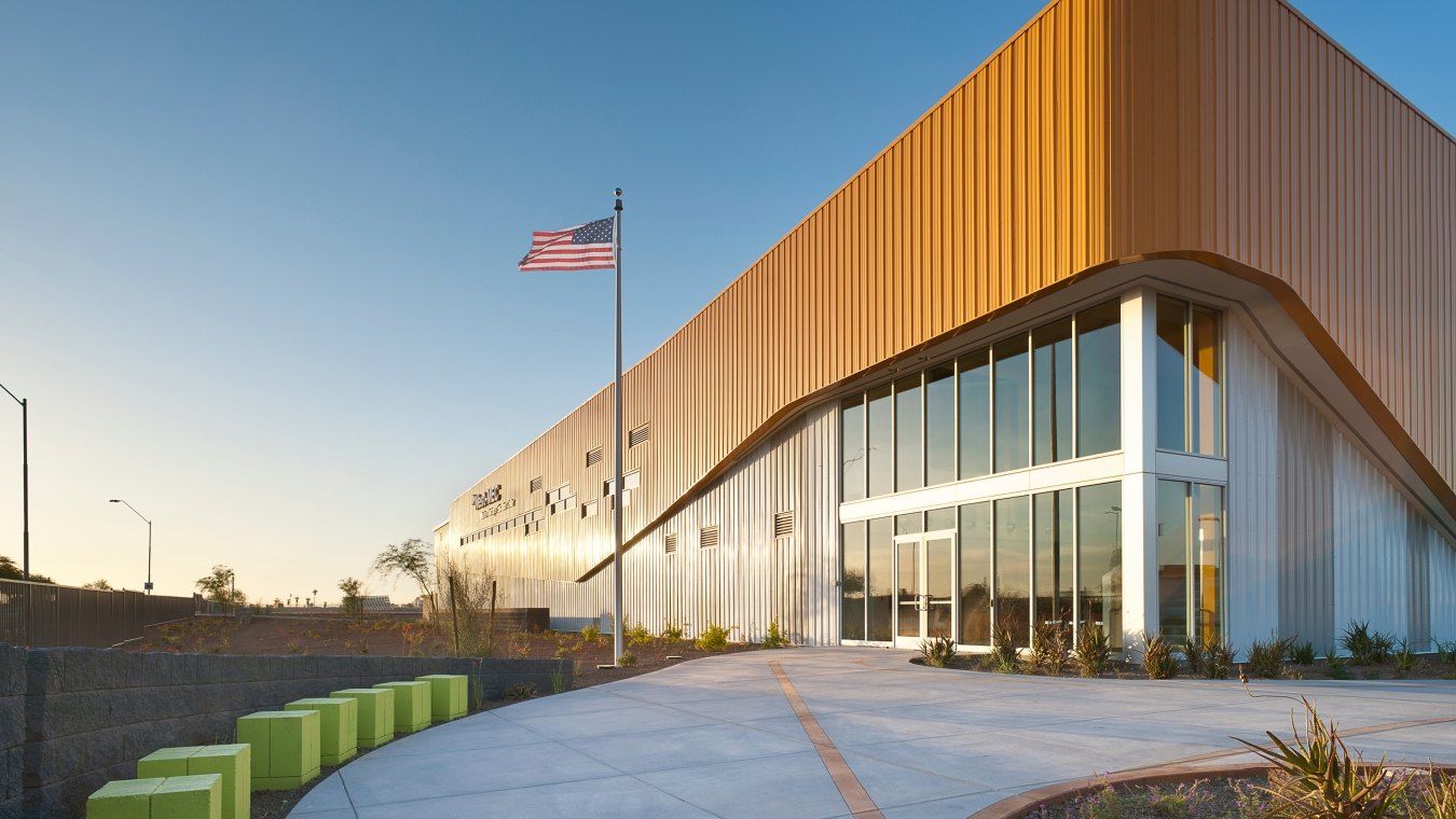 Outdoor image of the enterance with a flag pole and green seats