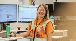 employee smiling at camera at desk