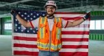 A person wearing PPE and holding a U.S. Flag behind their back