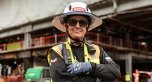 A person wearing PPE on a jobsite, standing with their arms crossed