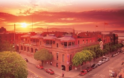 Aerial exterior view of The Cannery with a sunset in the background.