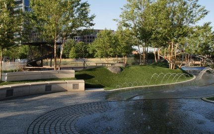 A fountain, bench, and greenery area at the park