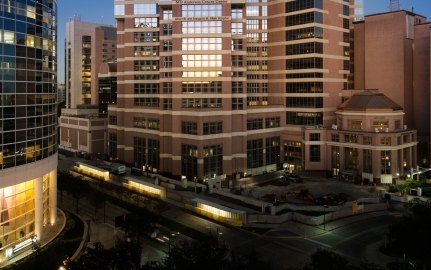 Exterior view of the tall hospital tower surrounded by other buildings.