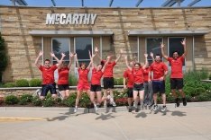 McCarthy employees jumping in the air.
