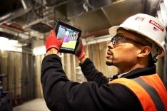 Construction worker looking at an Ipad on a jobsite.