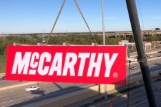 McCarthy logo sign being placed onto a building