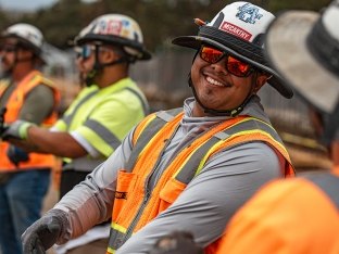 A person smiling while wearing PPE on the jobsite