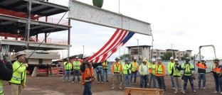Construction workers on jobsite at topping out event.