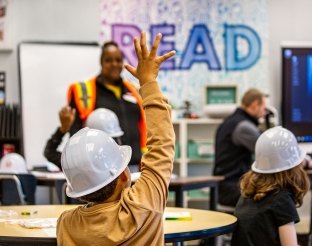 Child raising their hand. 