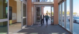 Two people walking into a building