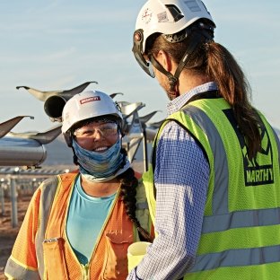 two employees having a conversation on a solar field