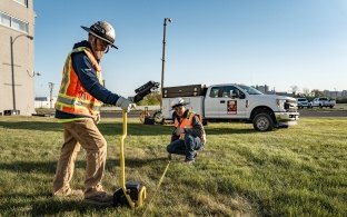 Two people working with a piece of equipment