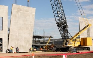 A crawler crane lifting up a concrete tilt wall panel