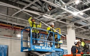 Two people standing on a lift