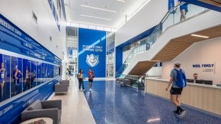 Student Athletics center lobby for Saint Louis University featuring royal blue and white accents and natural wood tones. 