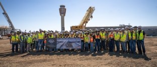 A group of people posing for a photo on a jobsite while wearing PPE