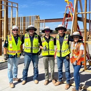 A group of five people wearing PPE on a jobsite
