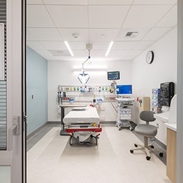 A patient room with a bed and monitor next to it