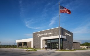 Exterior view of the medical facility with an American flag in front.