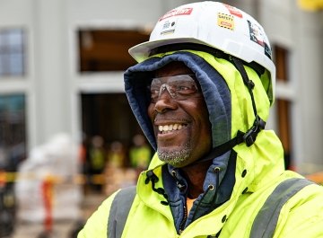 A person wearing PPE and smiling at a jobsite