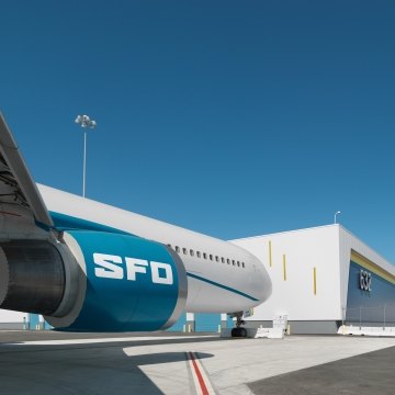 A parked airplane with letters SFO on the engine.