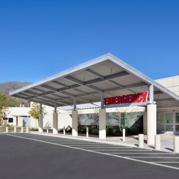 Outdoor entrance to the emergency room with trees and hills in the background