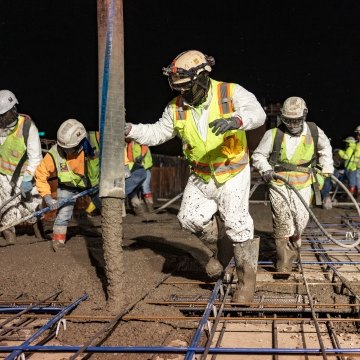 A group of people working on a concrete pour at night