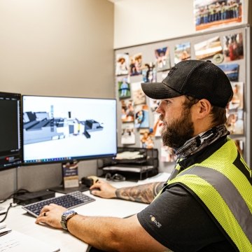 A person looking at two computer monitors