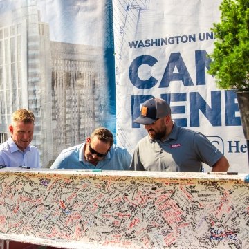 people signing a beam at a topping out ceremony