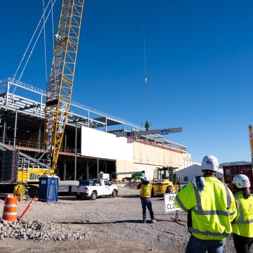 A couple of people standing in front of a building under construction