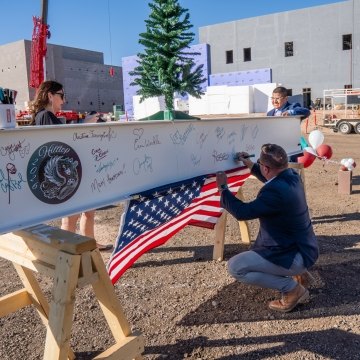 People signing a beam