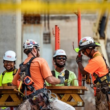 Four people wearing PPE working together on a jobsite