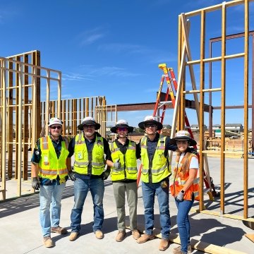 A group of five people wearing PPE on a jobsite
