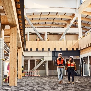 Two people wearing PPE and walking through a jobsite 