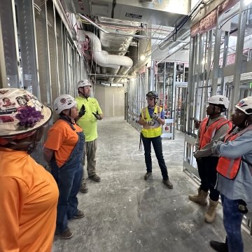 A group of people wearing PPE and talking on a jobsite