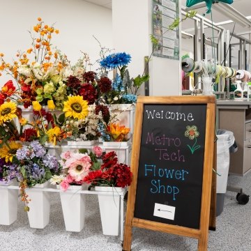 A welcome sign next to some flowers