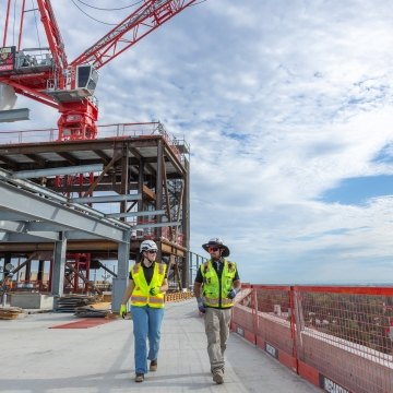 Two people walking on a jobsite wearing PPE