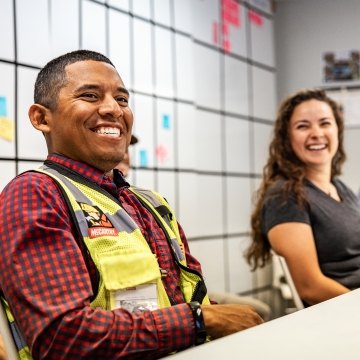 Two people sitting at a table and smiling